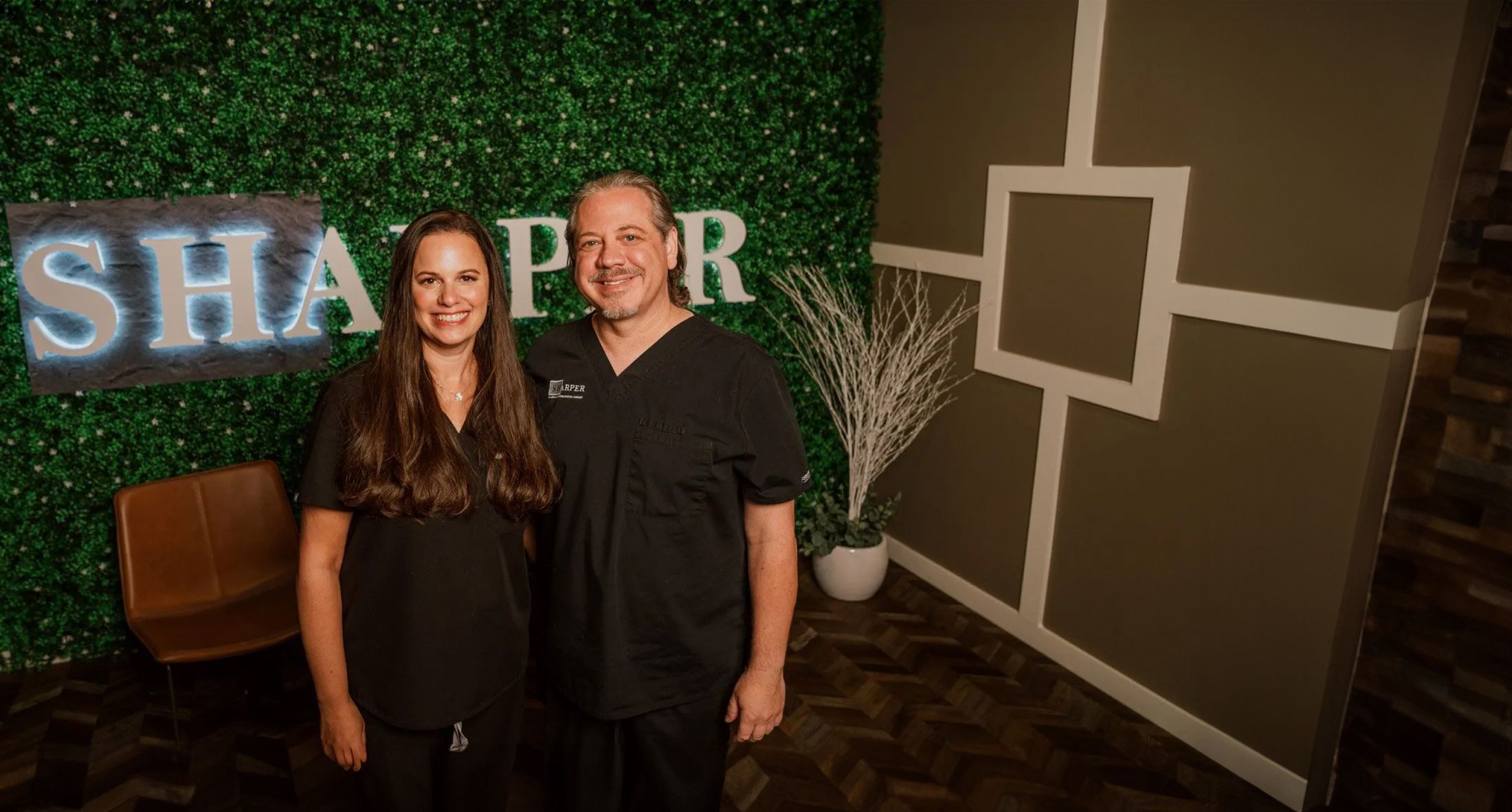 Two professionals posing in a modern clinic.