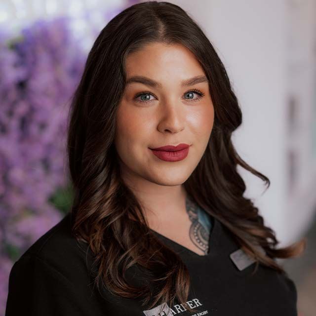 Person smiling with floral background.