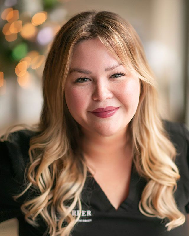 Smiling woman with long, blonde hair indoors.