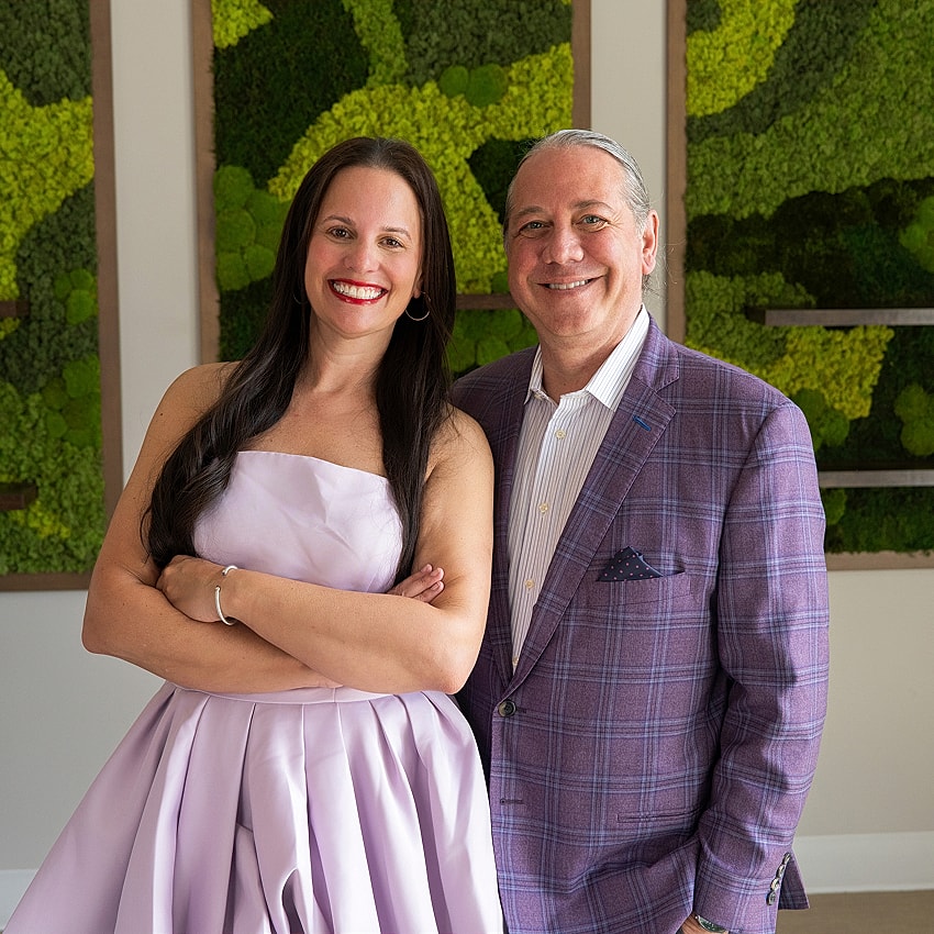 Couple posing together in stylish attire.