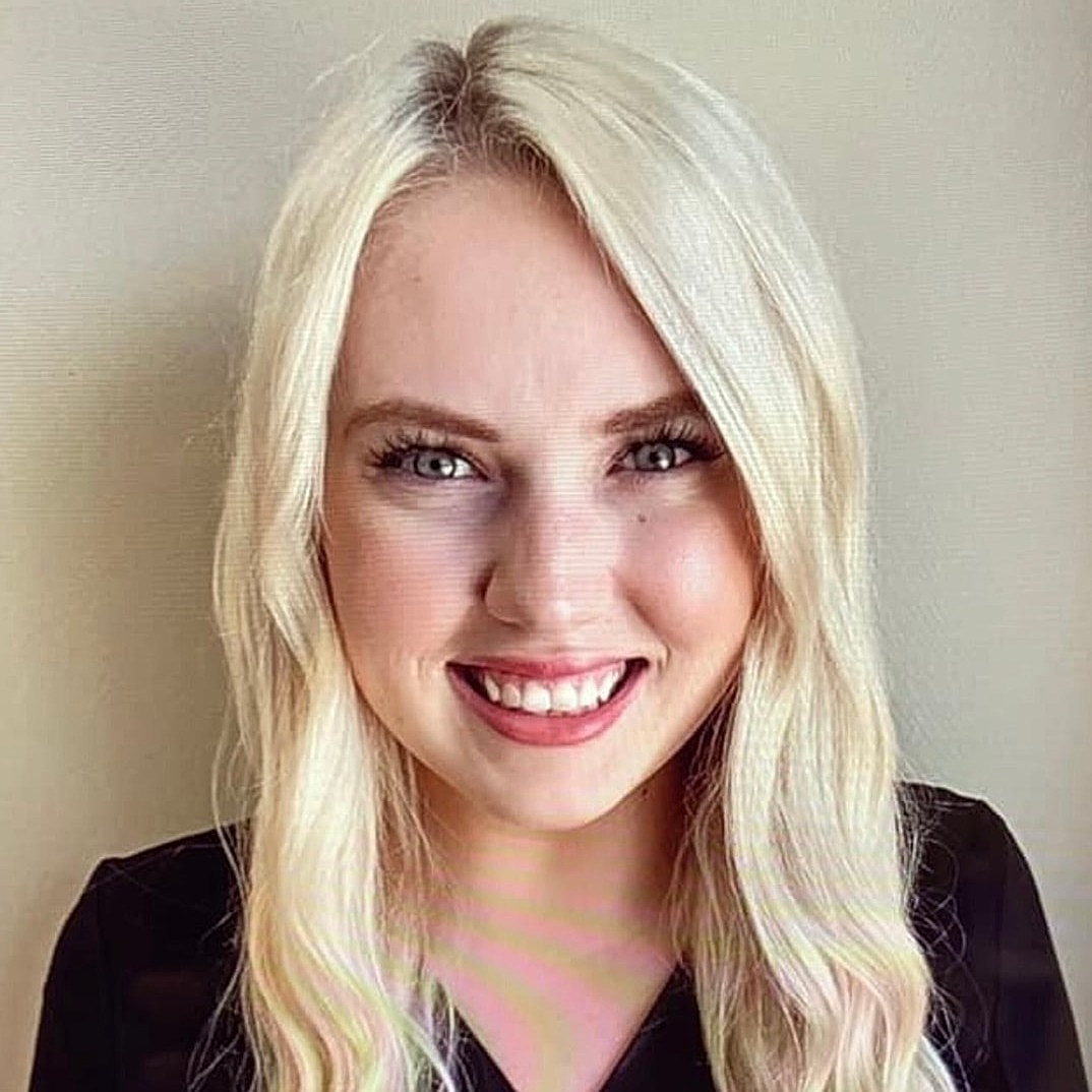 Smiling young woman with blonde hair.