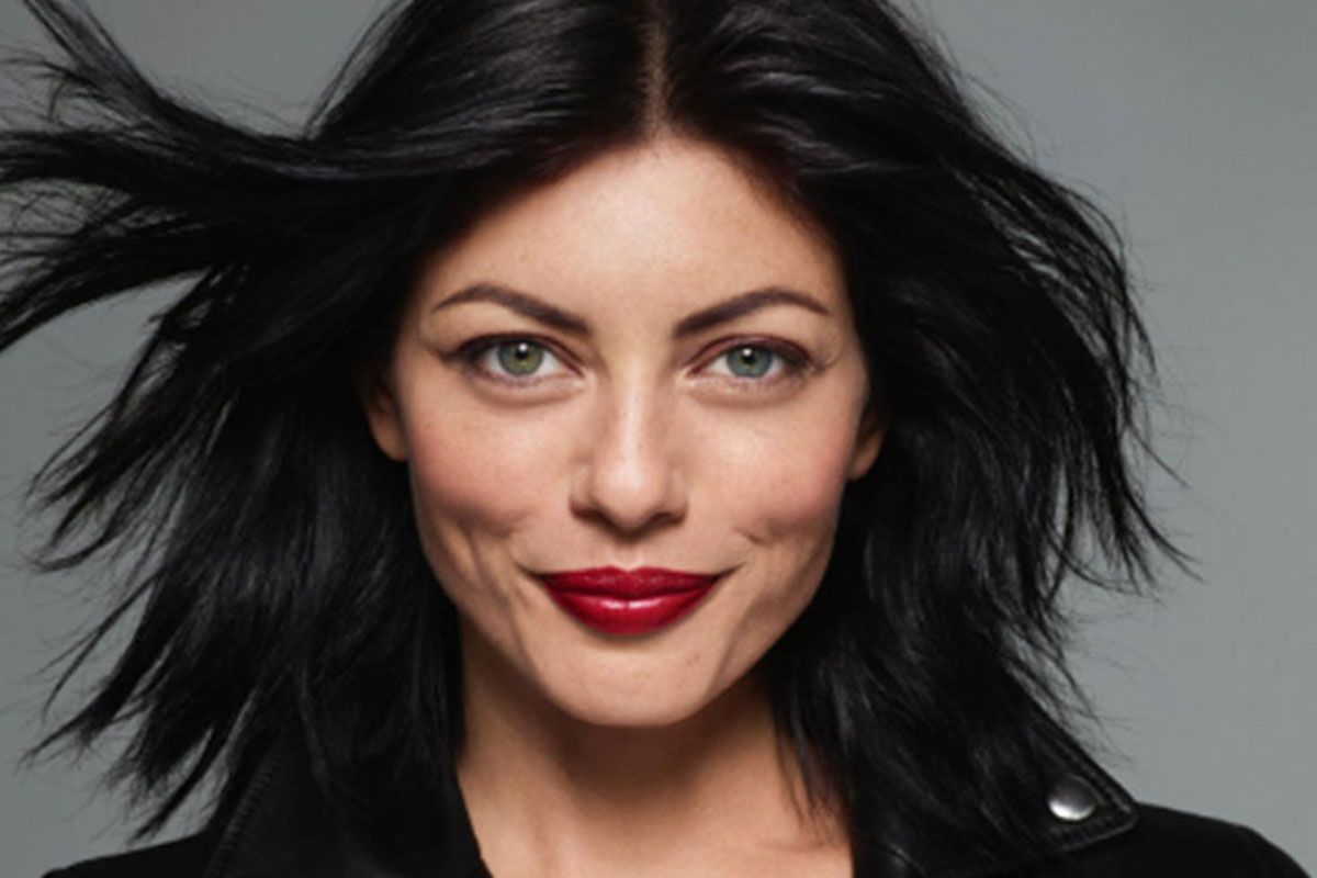 Woman with flowing black hair and red lipstick.