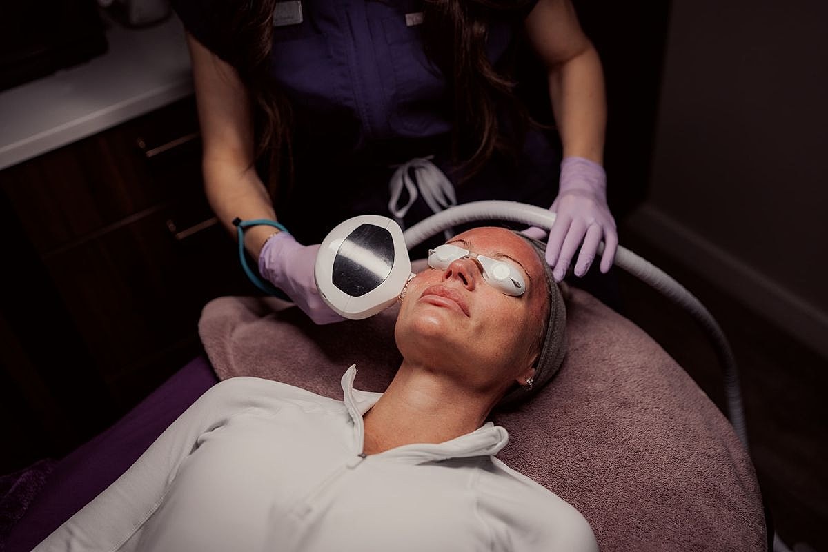 Woman receiving facial treatment in spa setting.