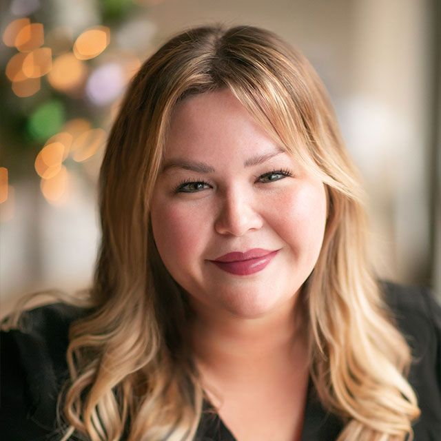 Smiling woman with long, wavy blonde hair.