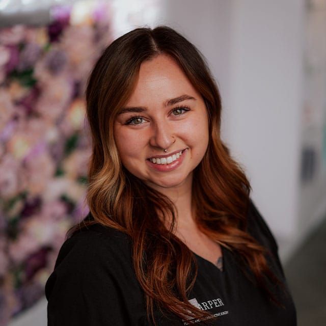 Smiling woman with long brown hair indoor.