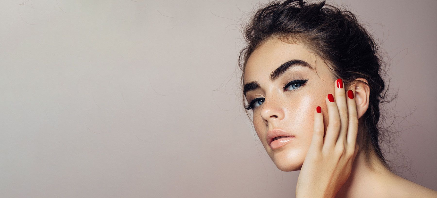 Model with stylish makeup and red nails.