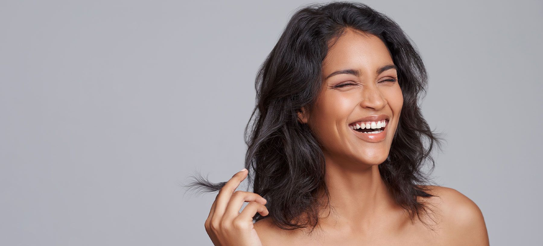 Smiling woman with long, wavy hair.