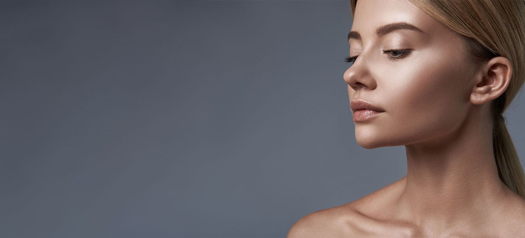 Profile of a woman against a gray background.